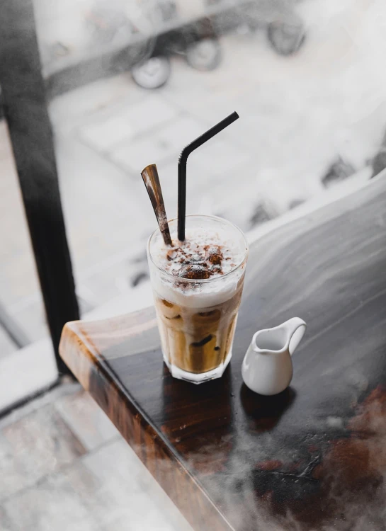 a glass of coffee on a black table