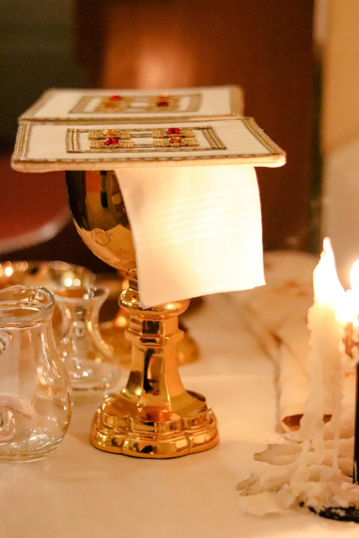 candle holders set up in front of white table cloth with candles