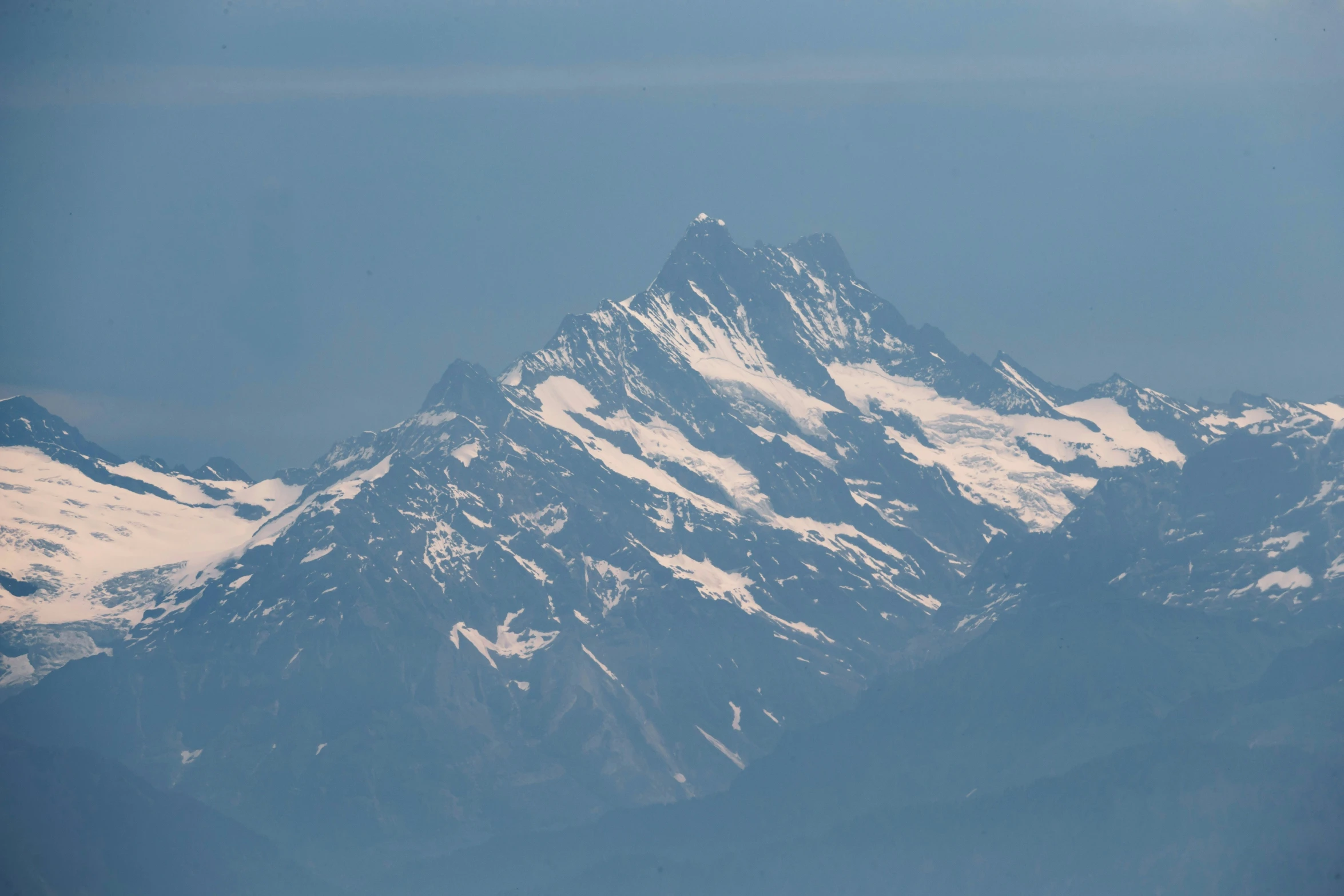 the top of a mountain towering into a blue sky