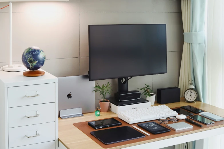 computer keyboard and monitor on top of the desk