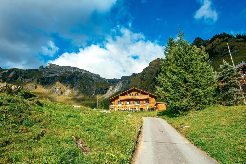 a narrow dirt road winding through a lush green hillside