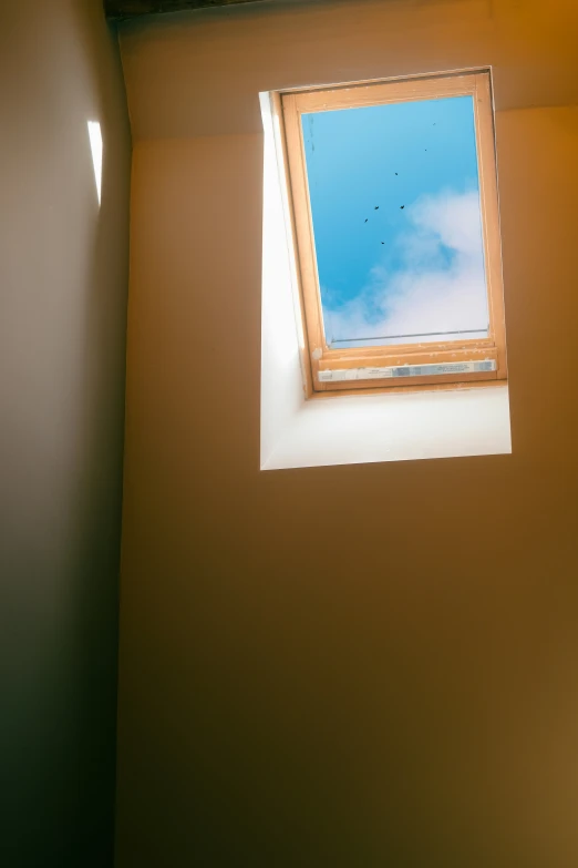 a small open window on top of a white wall