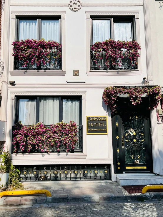 the front of a building with flower boxes in the windows