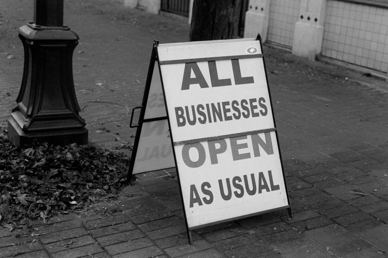 an all businesses open sign sitting on the side of the road