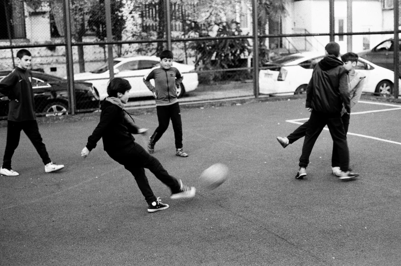 a man and a group of children play soccer on the court