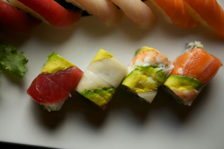 various kinds of sushi are arranged on a board