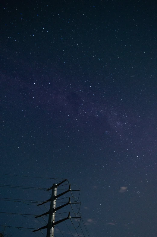 an image of the night sky over electrical poles