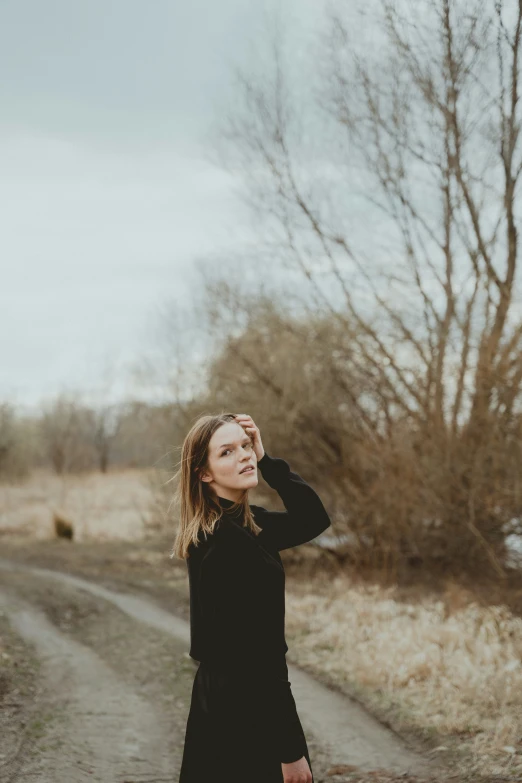 young woman wearing black standing on the road