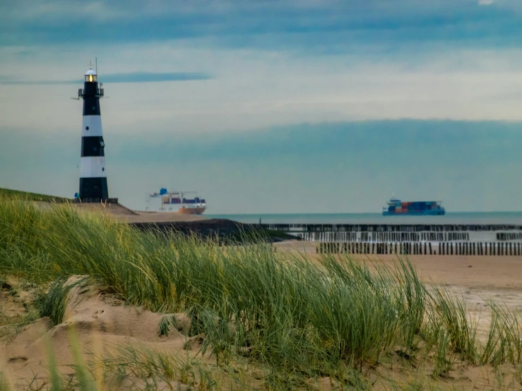 a light house on a beach next to the ocean