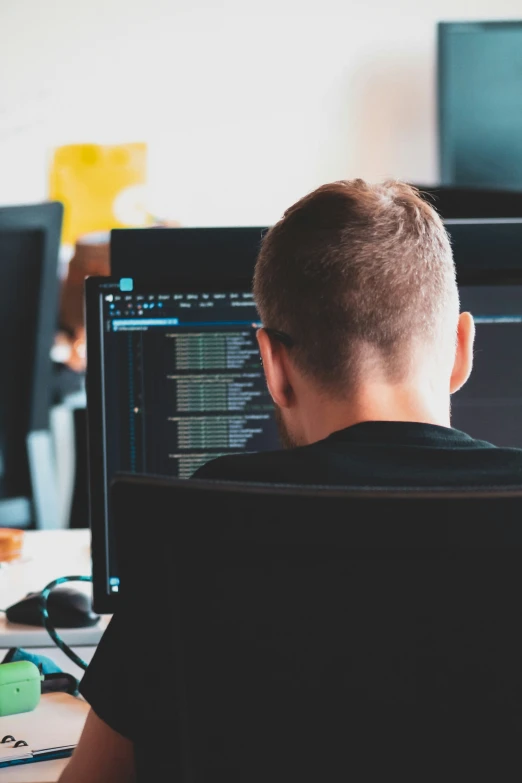 a man works on a computer at his desk