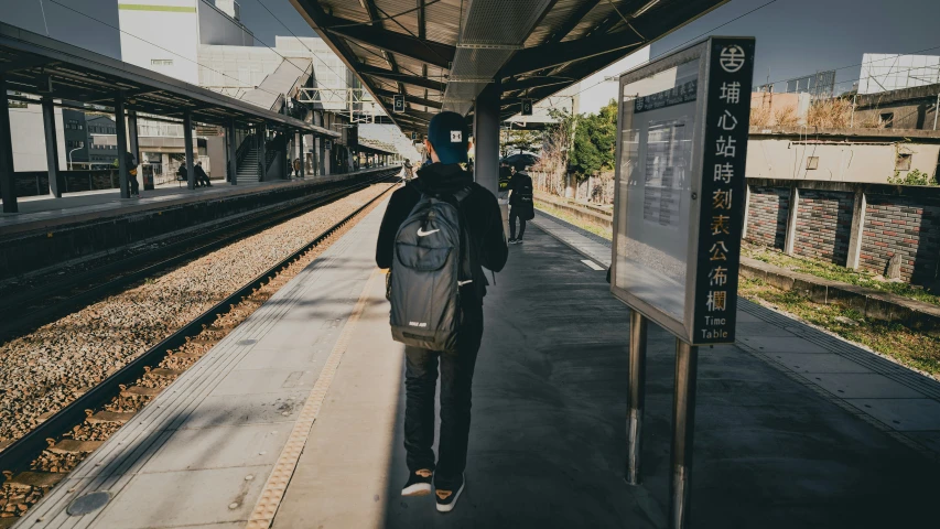 a man walking towards an outside train station