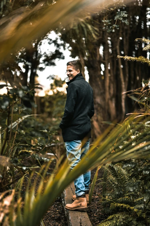 man walking along a wooden walkway in the woods