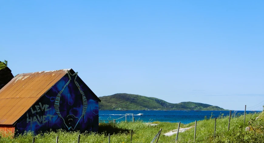 a building on the side of a lake with graffiti painted