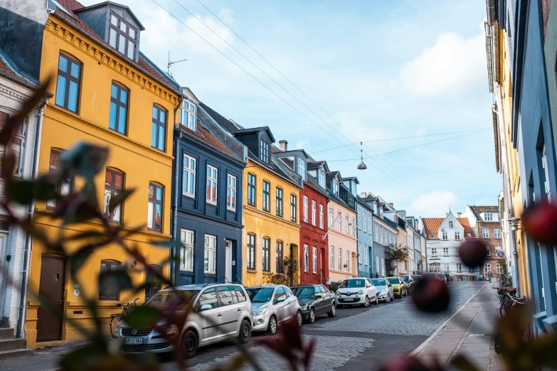 cars parked along a street lined with many colorful buildings