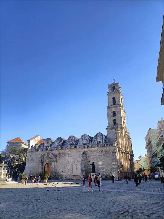 a stone street with two towers and people walking