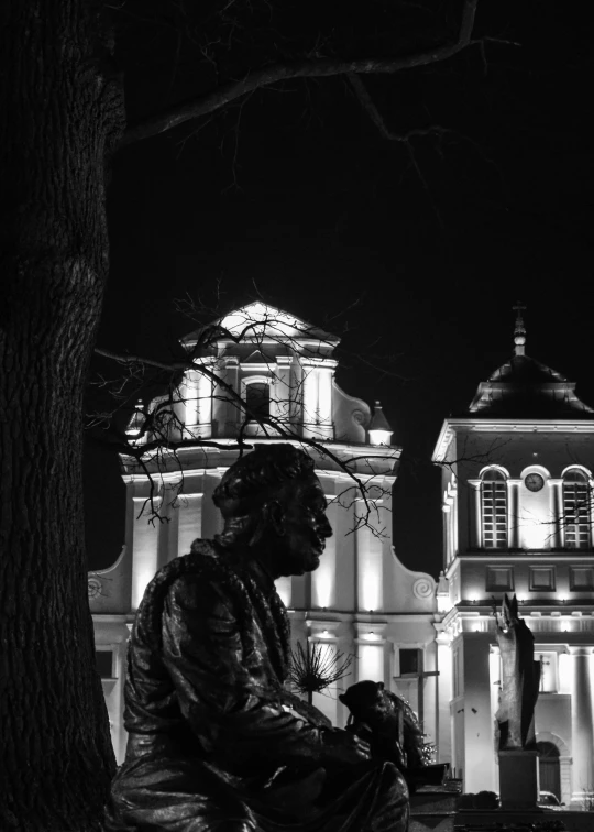 black and white po of a statue of a person near a building