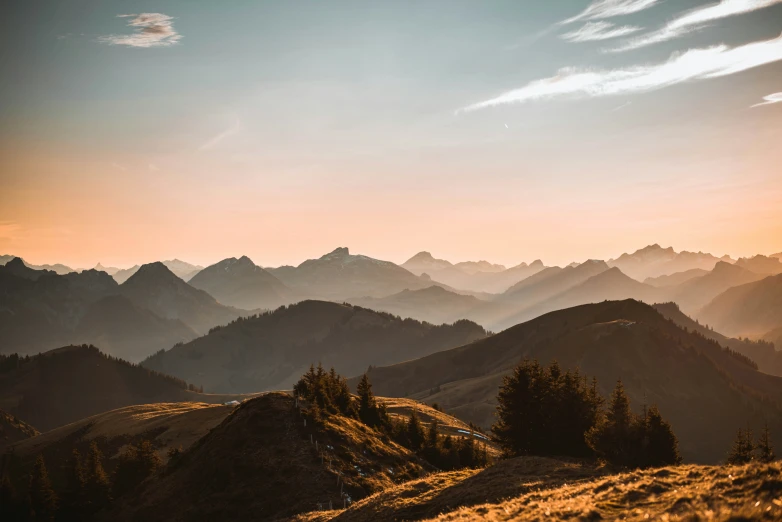 a beautiful sunset above the mountains and trees