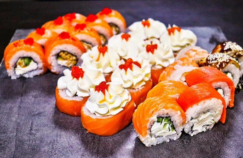 a collection of sushi on a black table