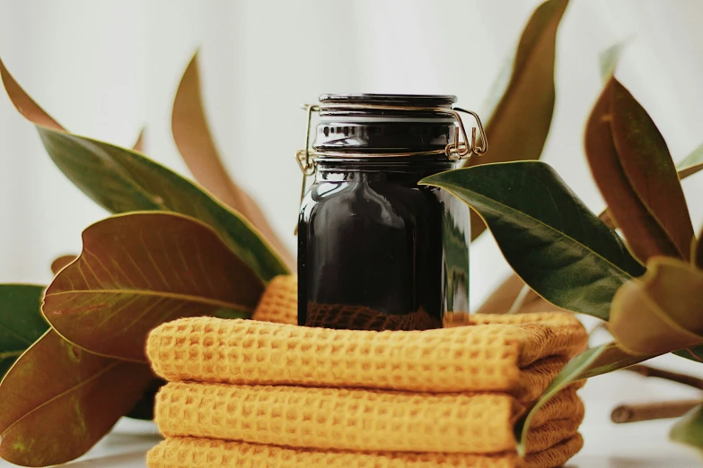 a jar with a lot of essential oils in it near towel