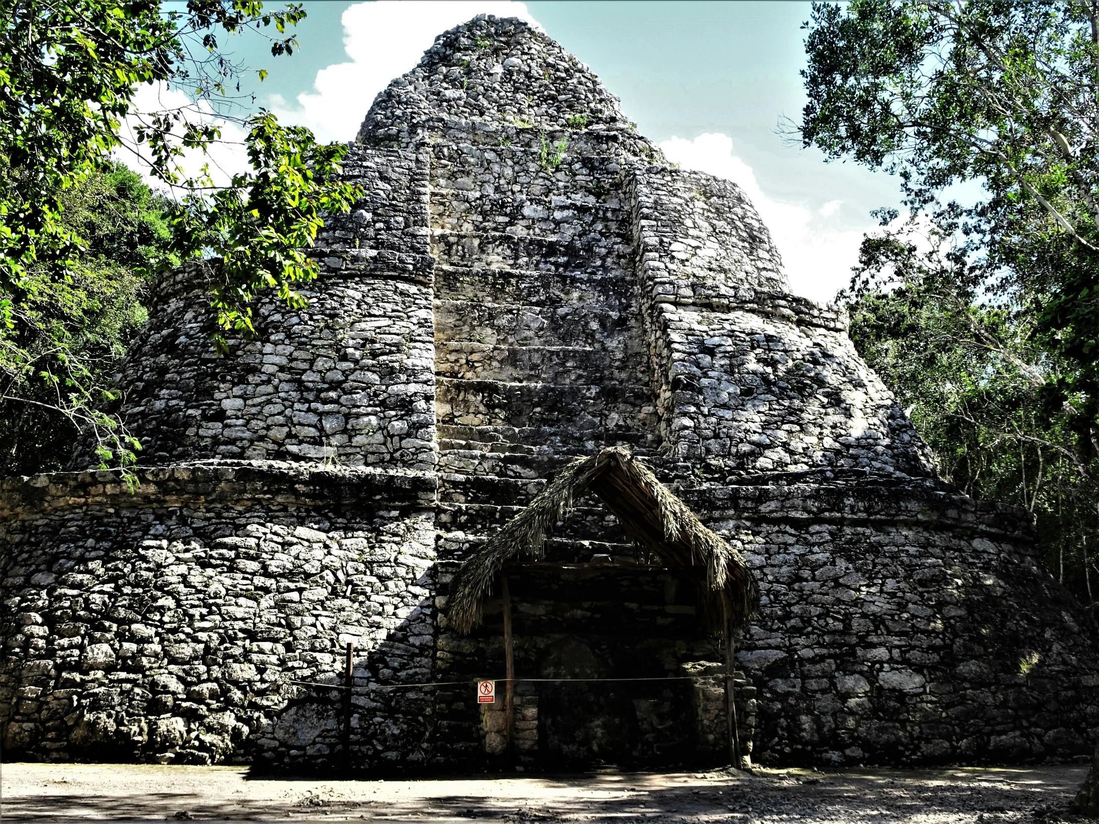 a brick structure near trees with no people inside