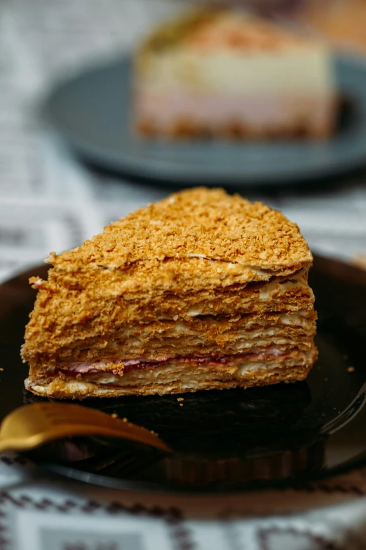 three layers of crumb - crusted dessert on a black plate
