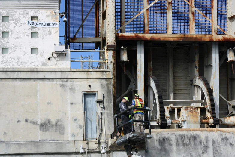 two men working on pipes going into a structure