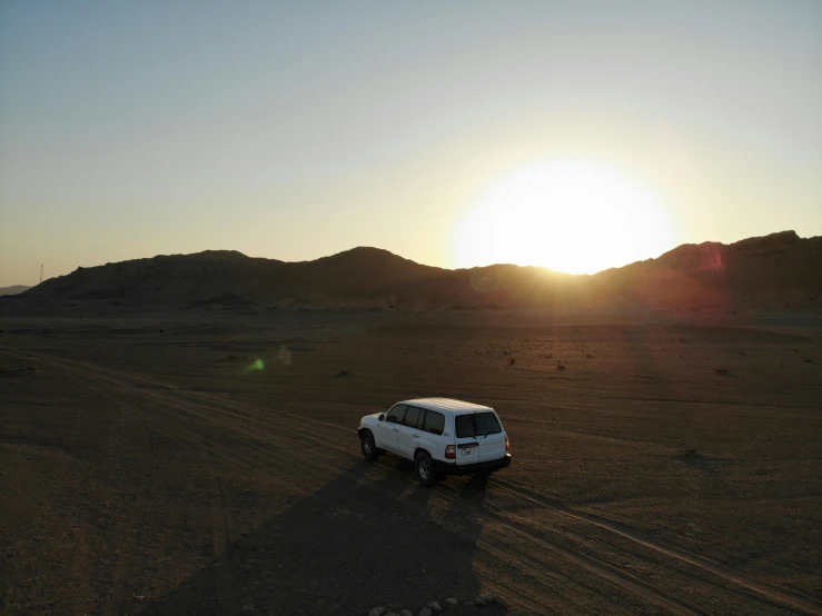 a white truck driving down a dry road