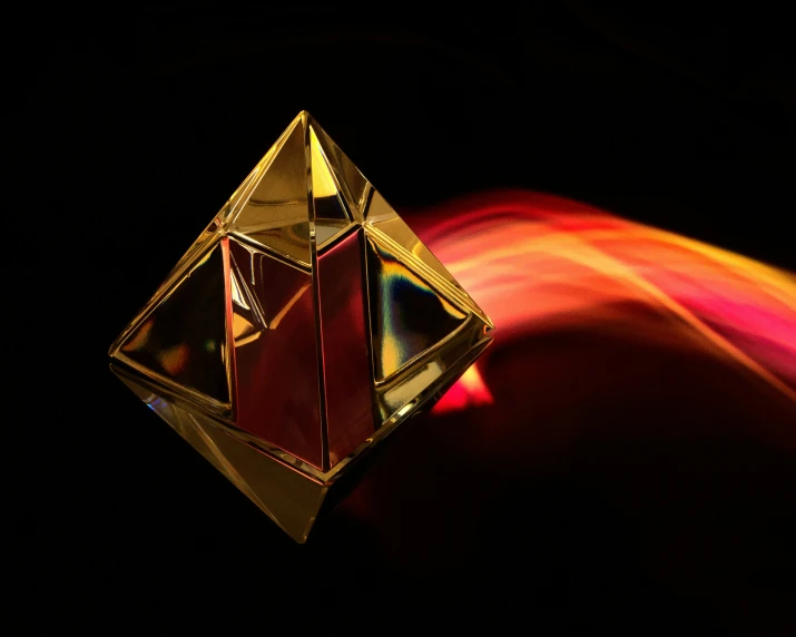 a red and yellow object sits in front of a black background