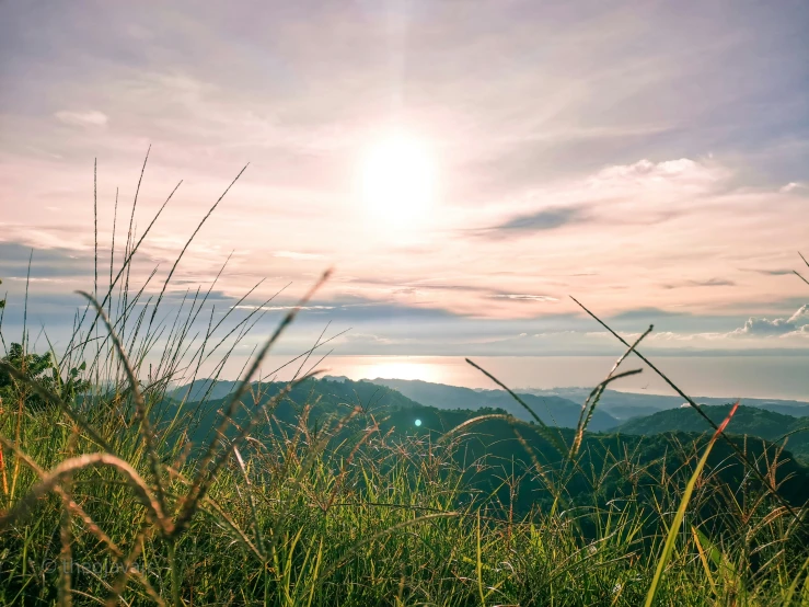 the view of mountains and trees, with the sun going down