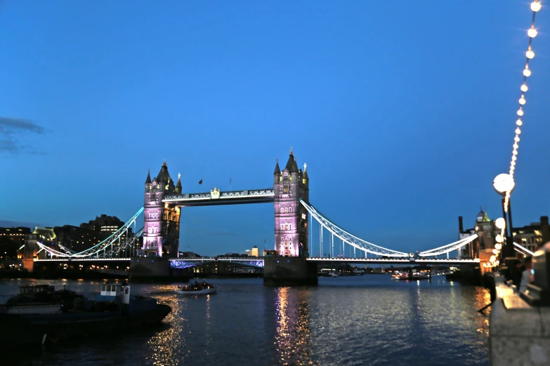 the city is lit up at night and there is also the tower bridge