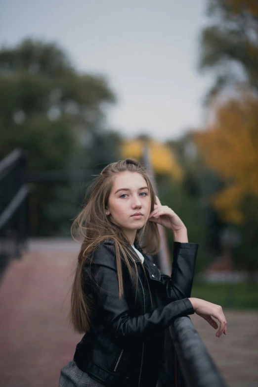 the woman is standing on a bridge looking off into the distance