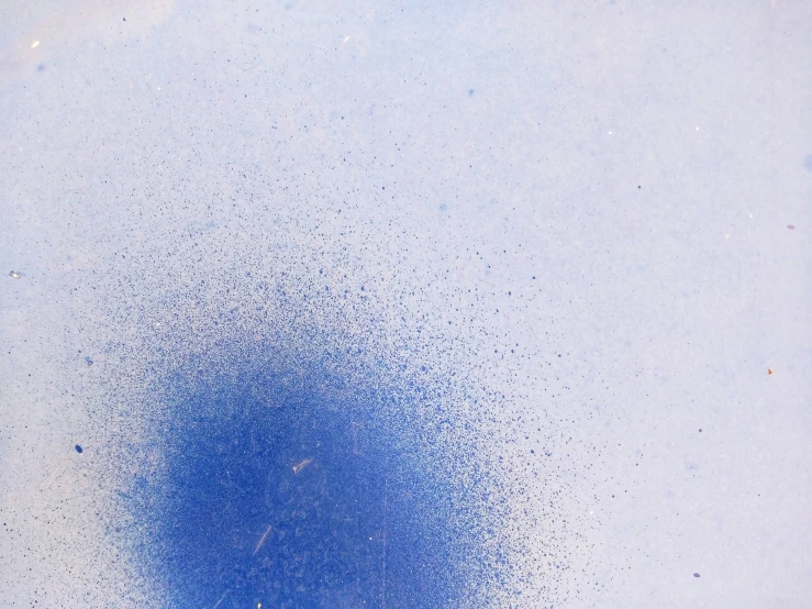 a blue object is splatting down on the surface