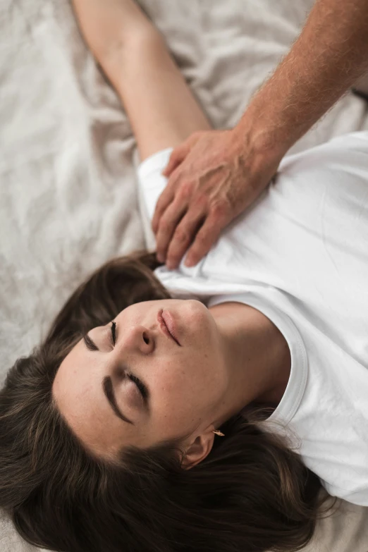 a woman is lying down with a white shirt