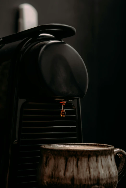 a espresso machine with a cup below it