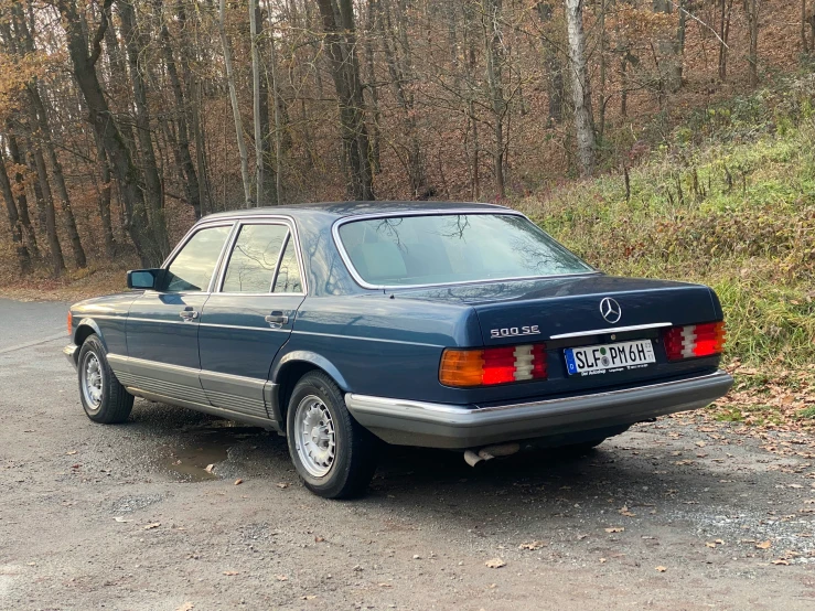 a dark blue car parked on top of a road