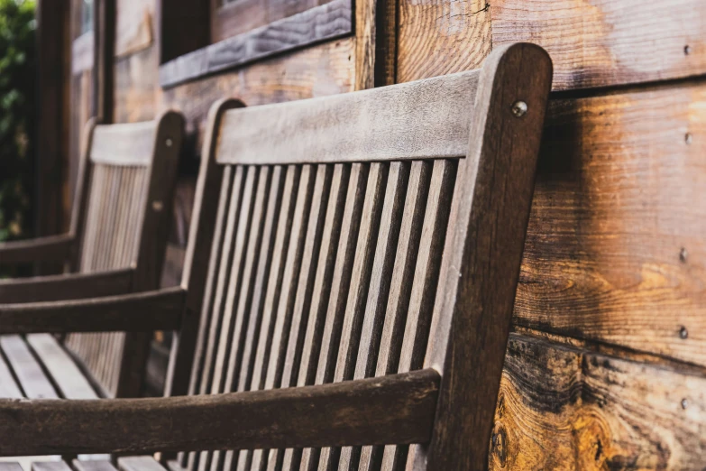 two brown benches with wood slats sit outside