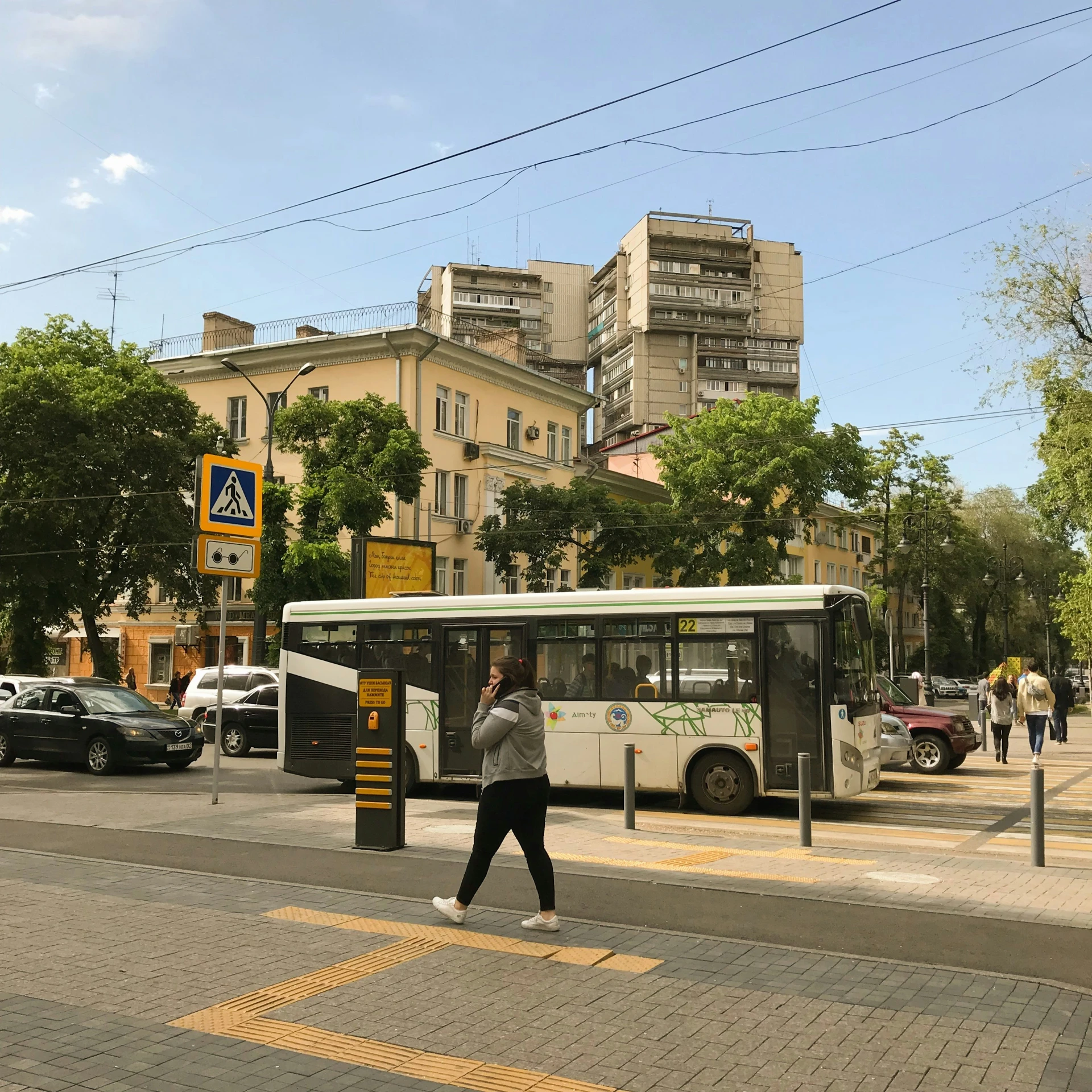 a man walks across a cross walk in front of a bus