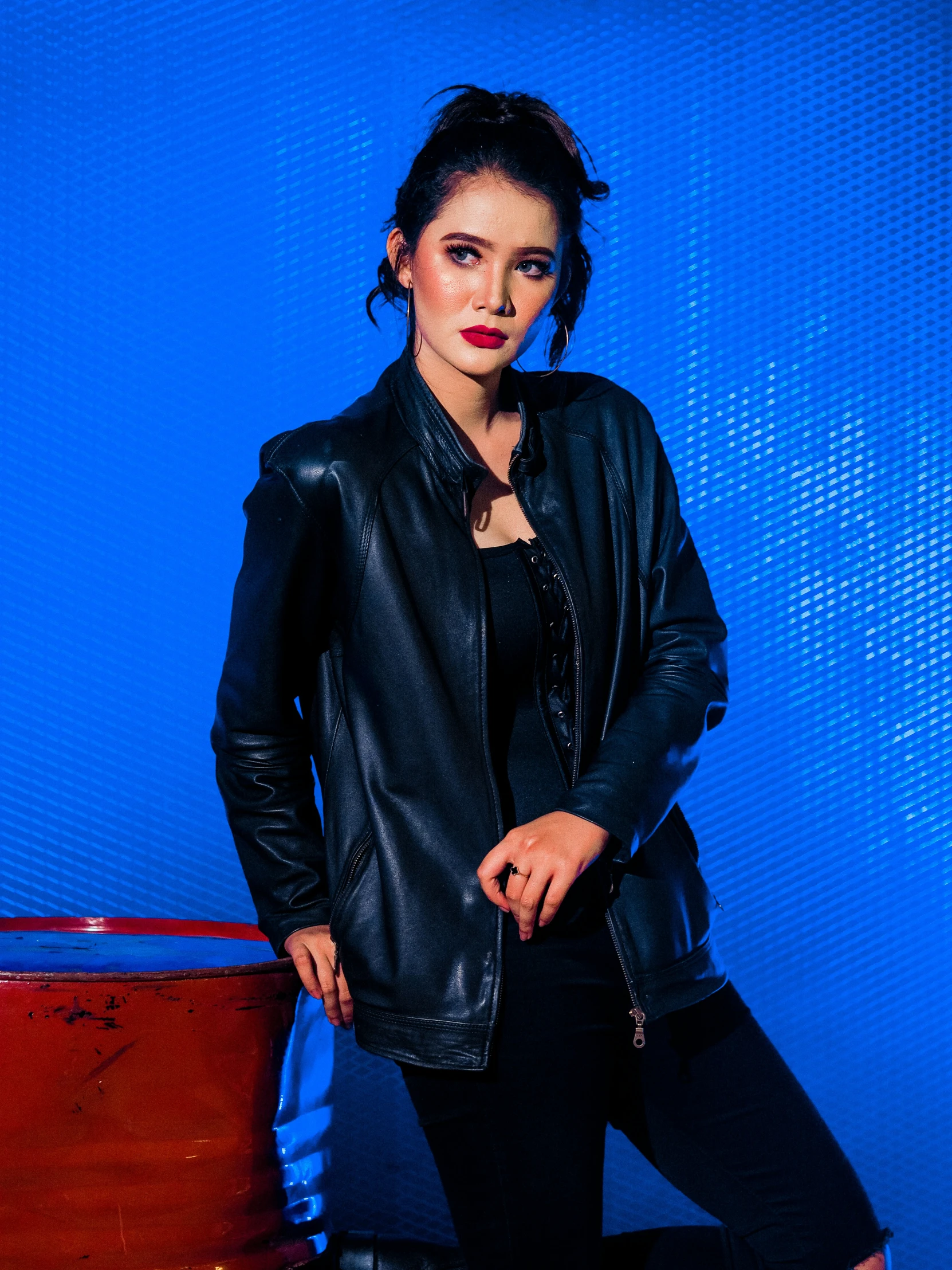 a woman is posing next to a suitcase