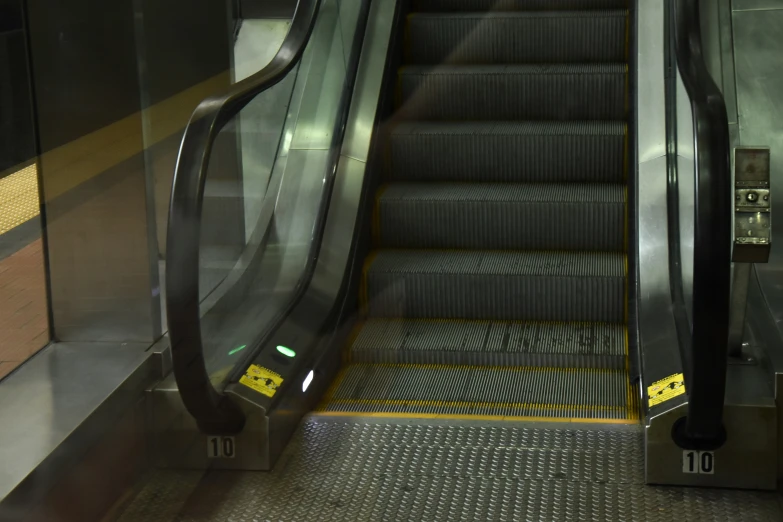 an escalator with metal handrails next to an empty floor