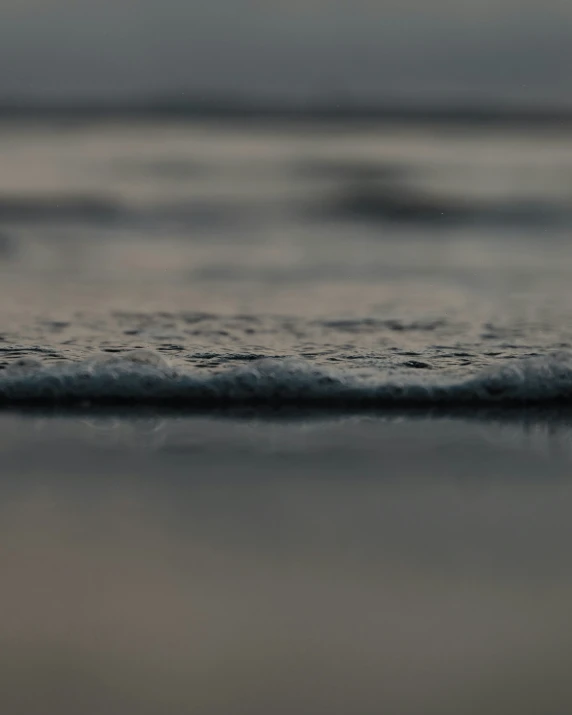 small wave crashing up on the beach near shore