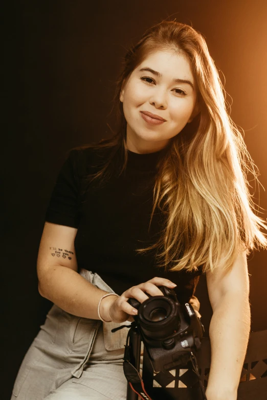 a woman is holding a camera on a stool