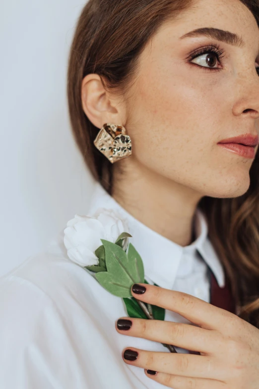 a young lady wearing green leaves and a white flower