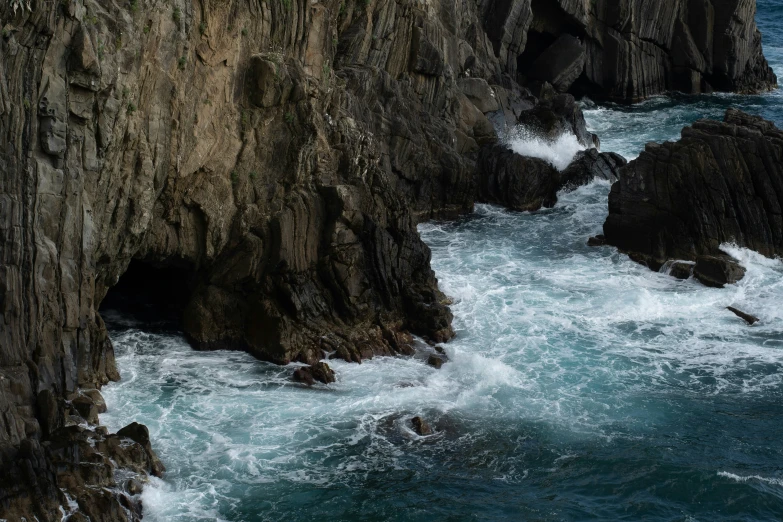 rocky cliffs over rough sea waves with an umbrella