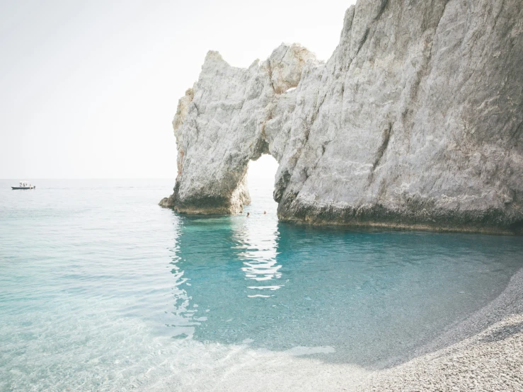 people walking around the edge of an ocean with the water