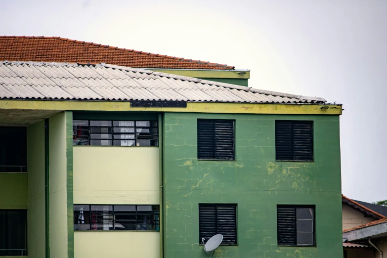 green building with a white satellite dish on it