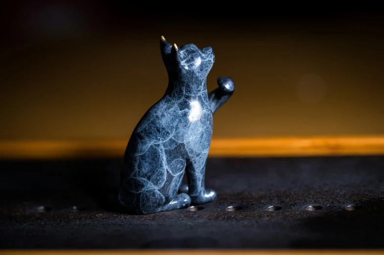 small silver cat statue sitting in the sun