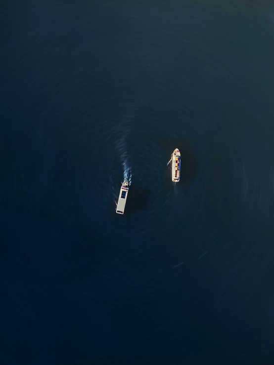three small boats in the middle of a large body of water
