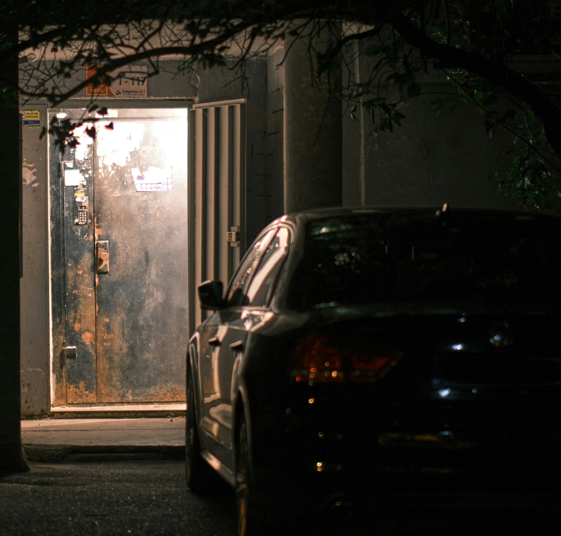 a car parked in front of an open door with parking meter