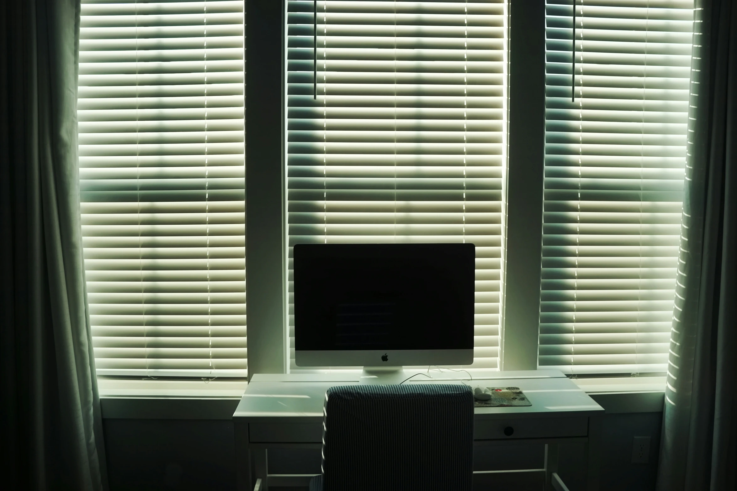 a computer monitor is sitting on top of a white desk