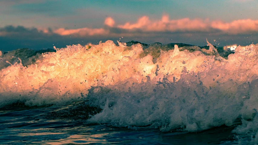 a surfer riding a wave in the ocean with the sun shining through